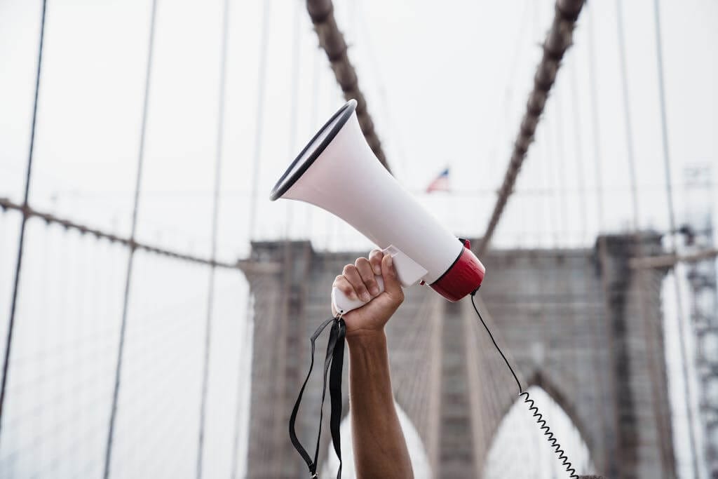 A protester raises a megaphone during a demonstration on the iconic Brooklyn Bridge.